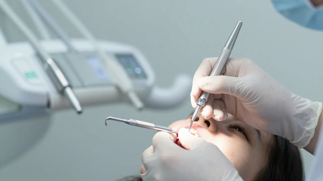 Stomatolog provádí kyretáž zubů v ordinaci