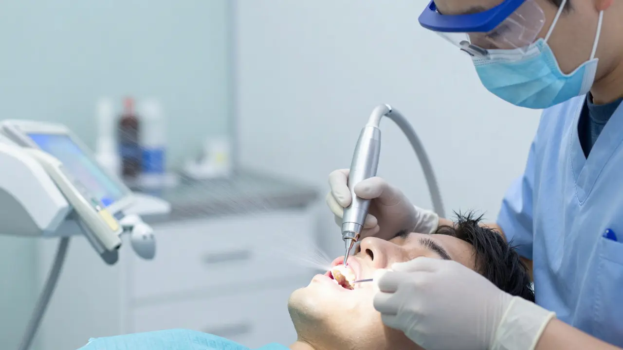 Dentální hygienista čistí zuby ultrazvukem